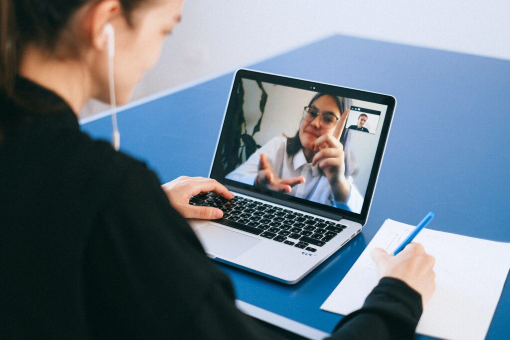 A person on a laptop with headphones in front of them.