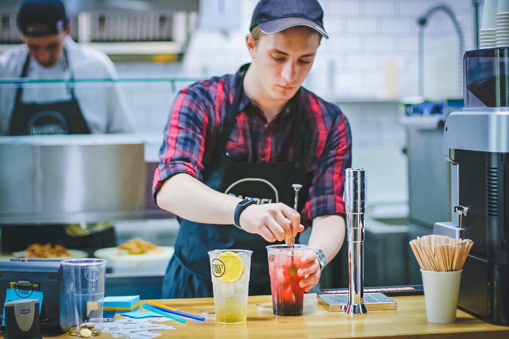 A man in an apron is making drinks.